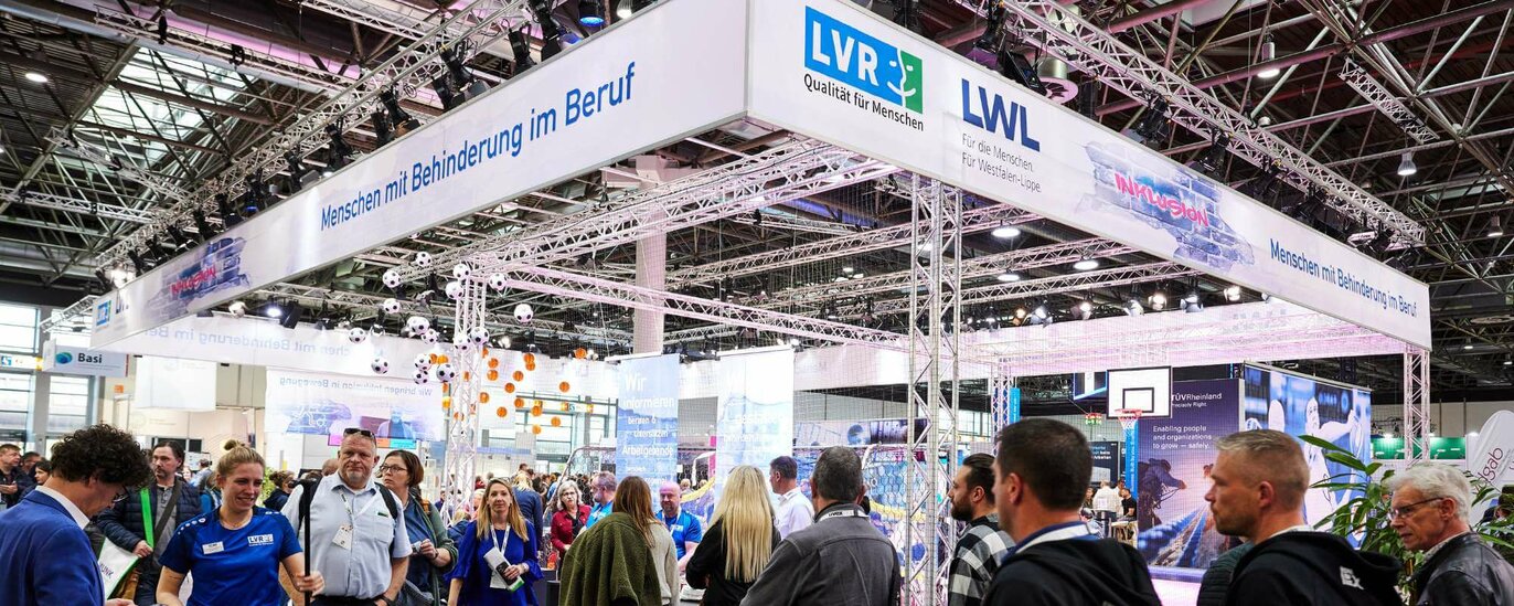 Ein großer hellerleuchteter Messestand. Darauf zu lesen ist blau auf weißem Grund: "LVR, Qualität für Menschen" und "LWL – für die Menschen, für Westfalen-Lippe"