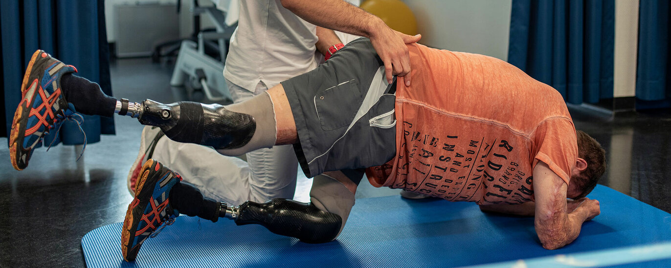 Ein Soldat mit einer Beinprothese wird in einer Rehaeinrichtung von einem Physiotherapeuten behandelt.