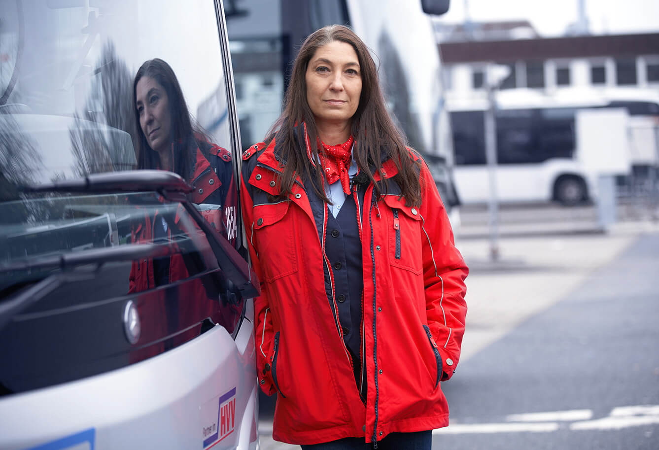 SBV Frau Herdegen lehnt an einem Bus.