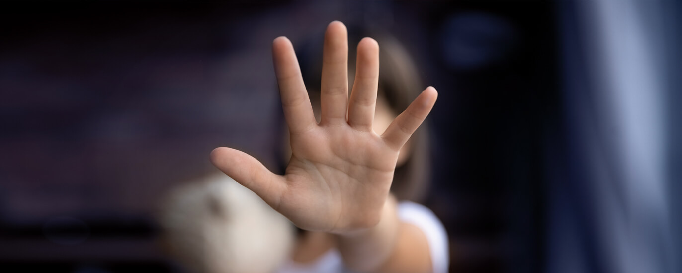 Abwehrende Mädchenhand als Geste gegen Gewalt. 