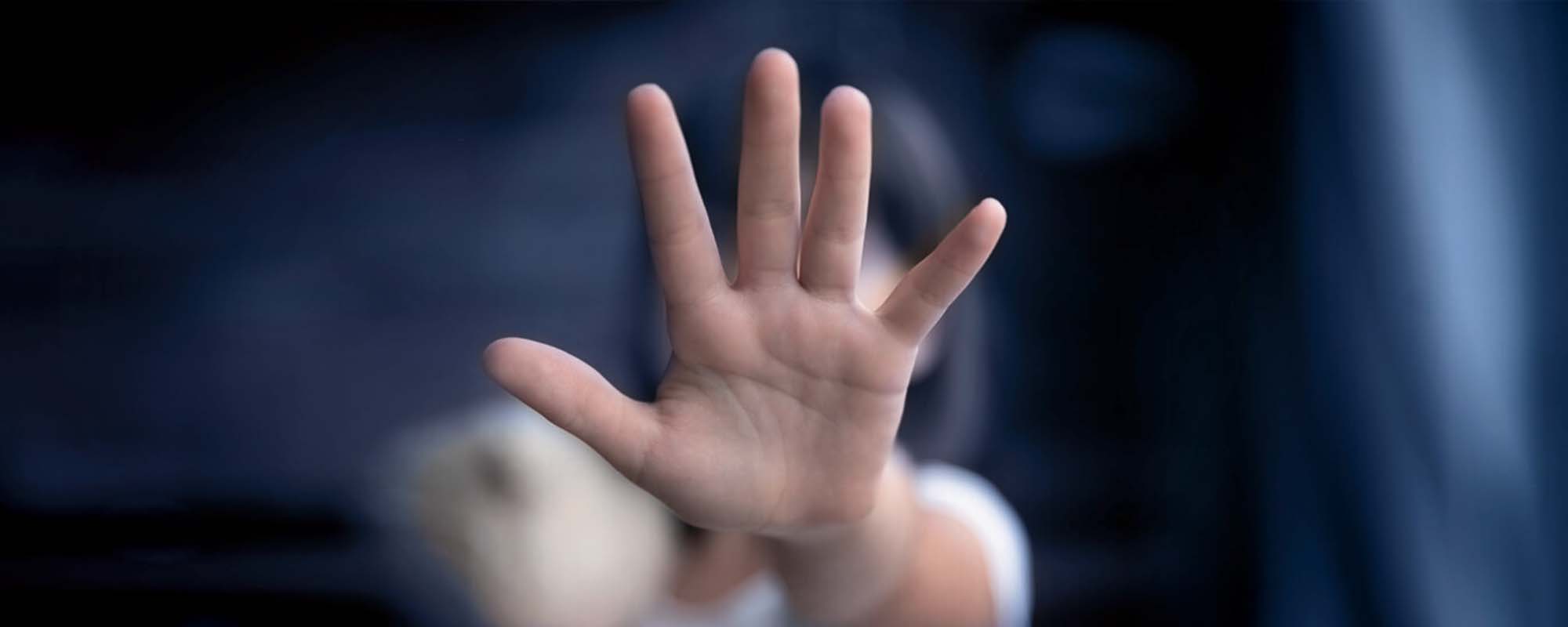 Abwehrende Mädchenhand als Geste gegen Gewalt. 