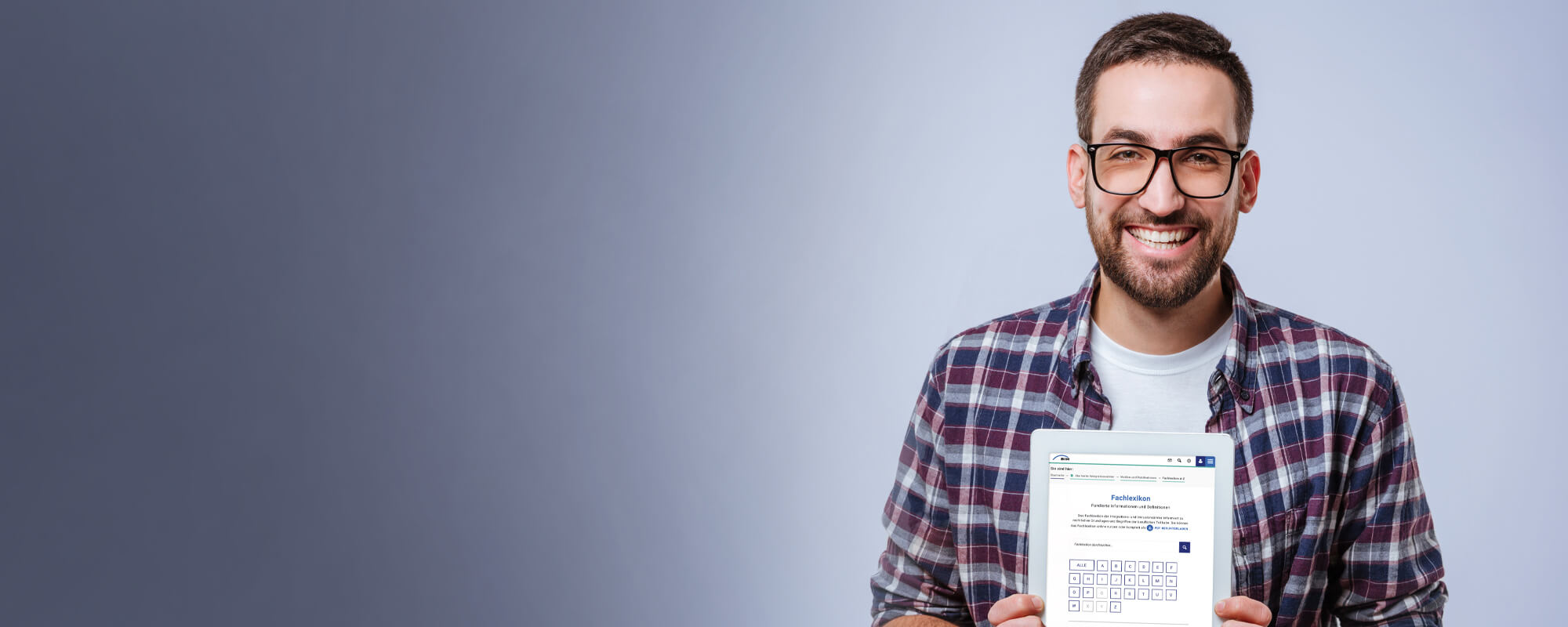 Ein lächelnder Mann hält ein Tablet in den Händen, auf dem die Seite des Fachlexikons zu sehen ist.