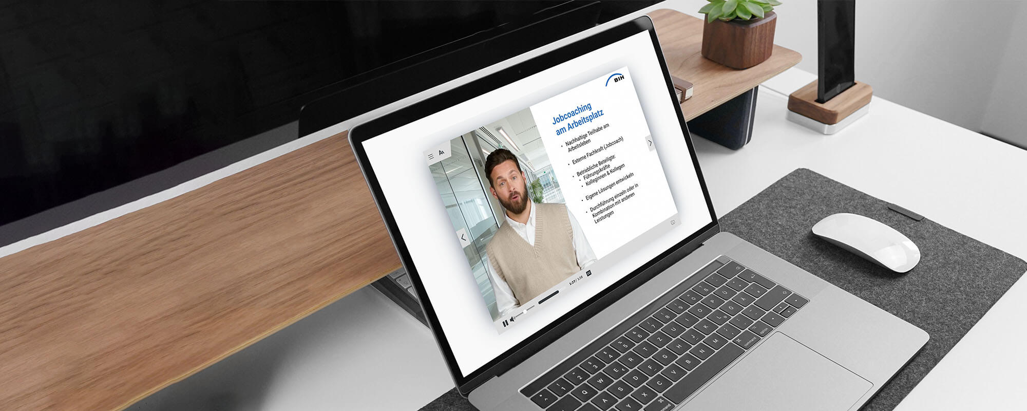 Auf einem Schreibtisch steht ein aufgeklapptes Notebook. Der Monitor zeigt einen Ausschnitt aus dem Microlearning „Jobcoaching am Arbeitsplatz”