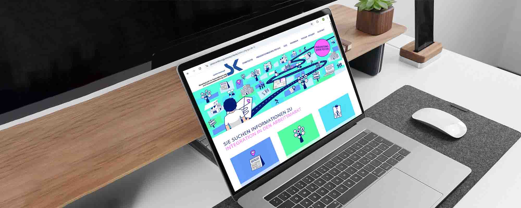 Das Foto zeigt einen aufgeklappten Laptop, der auf einem aufgeräumten Schreibtisch steht. Auf dem Bildschirm ist die Startseite des Informationsportals „Präventionsguide Psyche” zu sehen.