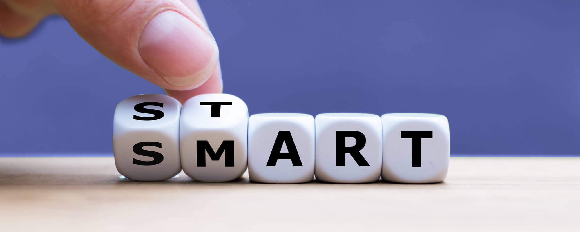 Smarter SBV-Start | © shutterstock/FrankHH Das Foto zeigt fünf Würfel. Statt Zahlen haben sie Buchstaben, die das Wort "Smart" ergeben. Eine Hand dreht die ersten beiden Würfel links im Bild, so dass gleichzeitig die "Start" und "Smart" zu lesen ist.