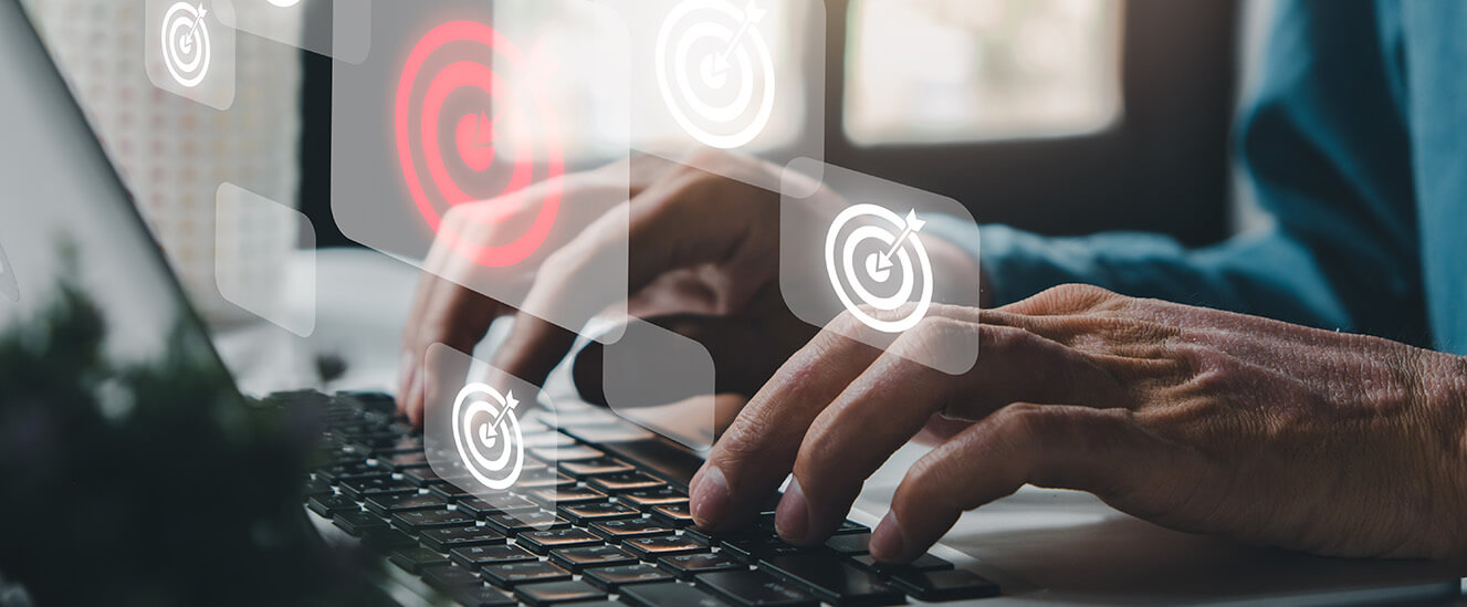 Ziele für die eigene als SBV setzen | © 2022 Mongta Studio/Shutterstock. No use without permission. Die Fotomontage zeigt die Hände einer Person, die auf der Tastatur eines Notebooks tippt. Im Vordergrund schweben kleine halbtransparente Zielscheiben.