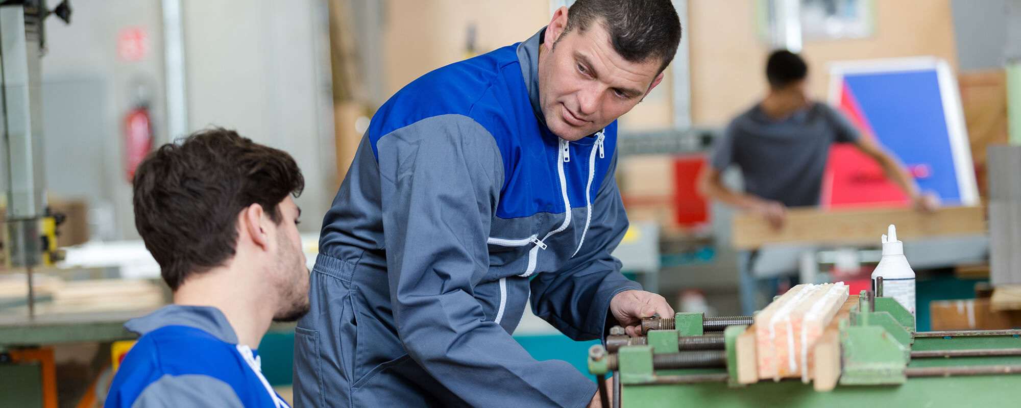 Beschäftigten in Werkstätten für Menschen mit Behinderung soll der Übergang in den allgemeinen Arbeitsmarkt erleichtert werden. | © shutterstock Ein Beschäftigter im Rollstuhl arbeitet in einer Werkstatt für Menschen mit Behinderung mit einem Kollegen an einer Werkbank
