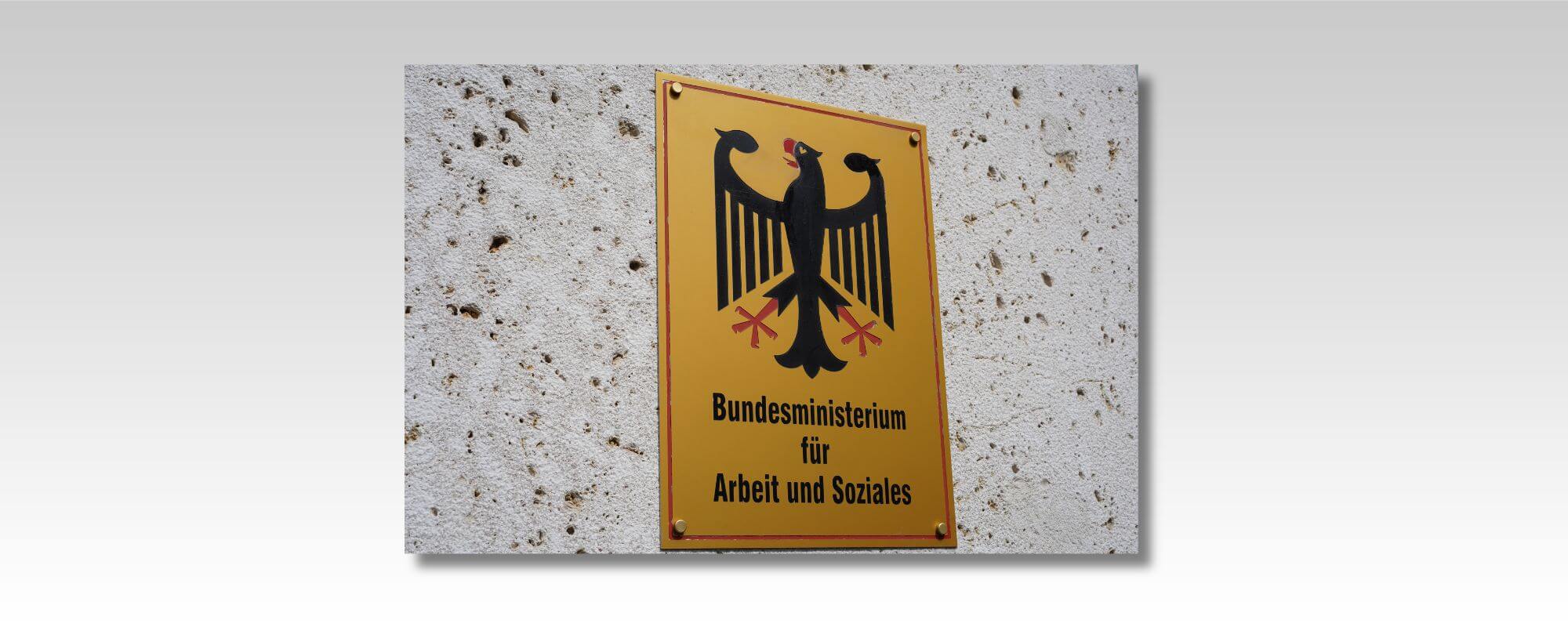 Das Foto zeigt eine Hauswand mit einem Messingschild. Darauf steht: „Bundesministerium für Arbeit und Soziales“