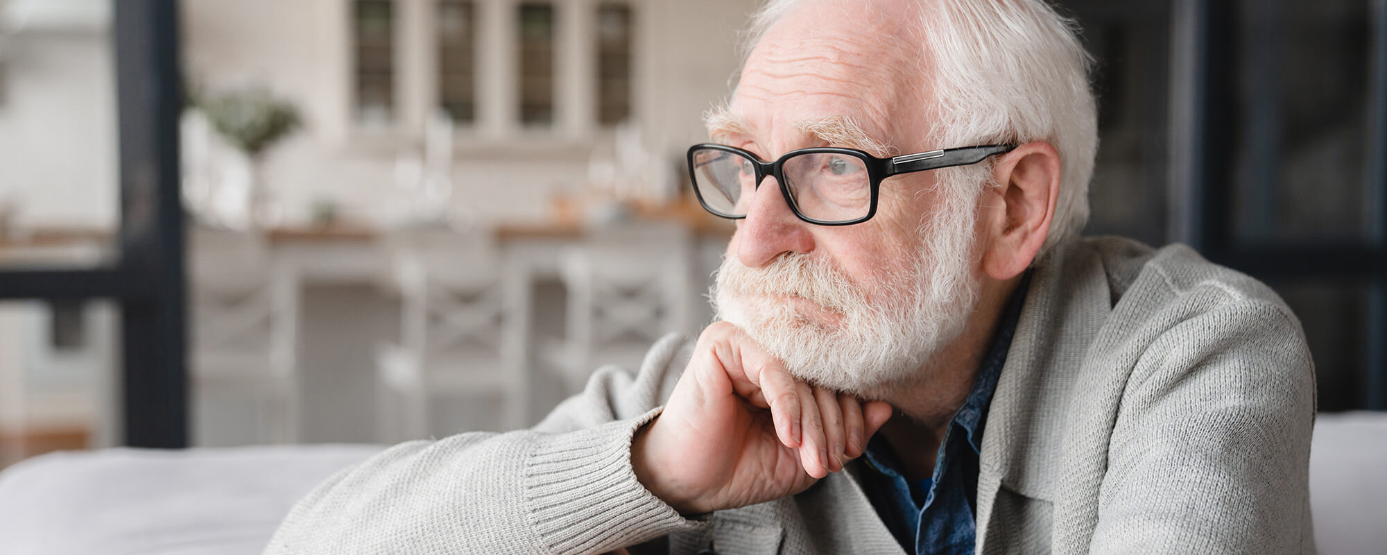 Ein älterer Mann mit Brille und weißem Vollbart schaut nachdenklich.