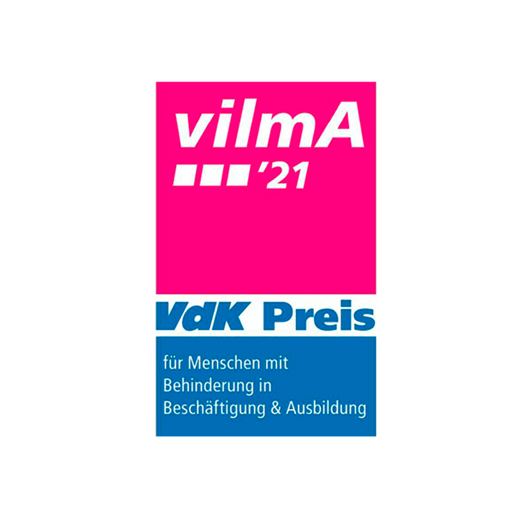 Logo des Vdk-Preises Vilma. Aufrechtstehendes Rechteck unterteilt in drei Flächen in pink, weiß und blau. Darauf steht ein Text.