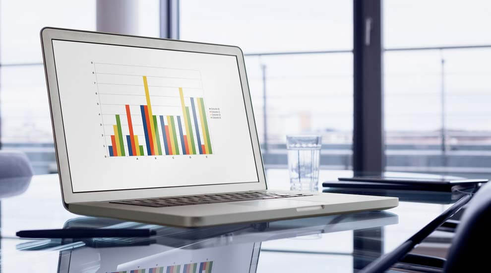 Foto eines Laptops auf einem Bürotisch, auf dem Bildschirm ist ein Diagramm zu sehen