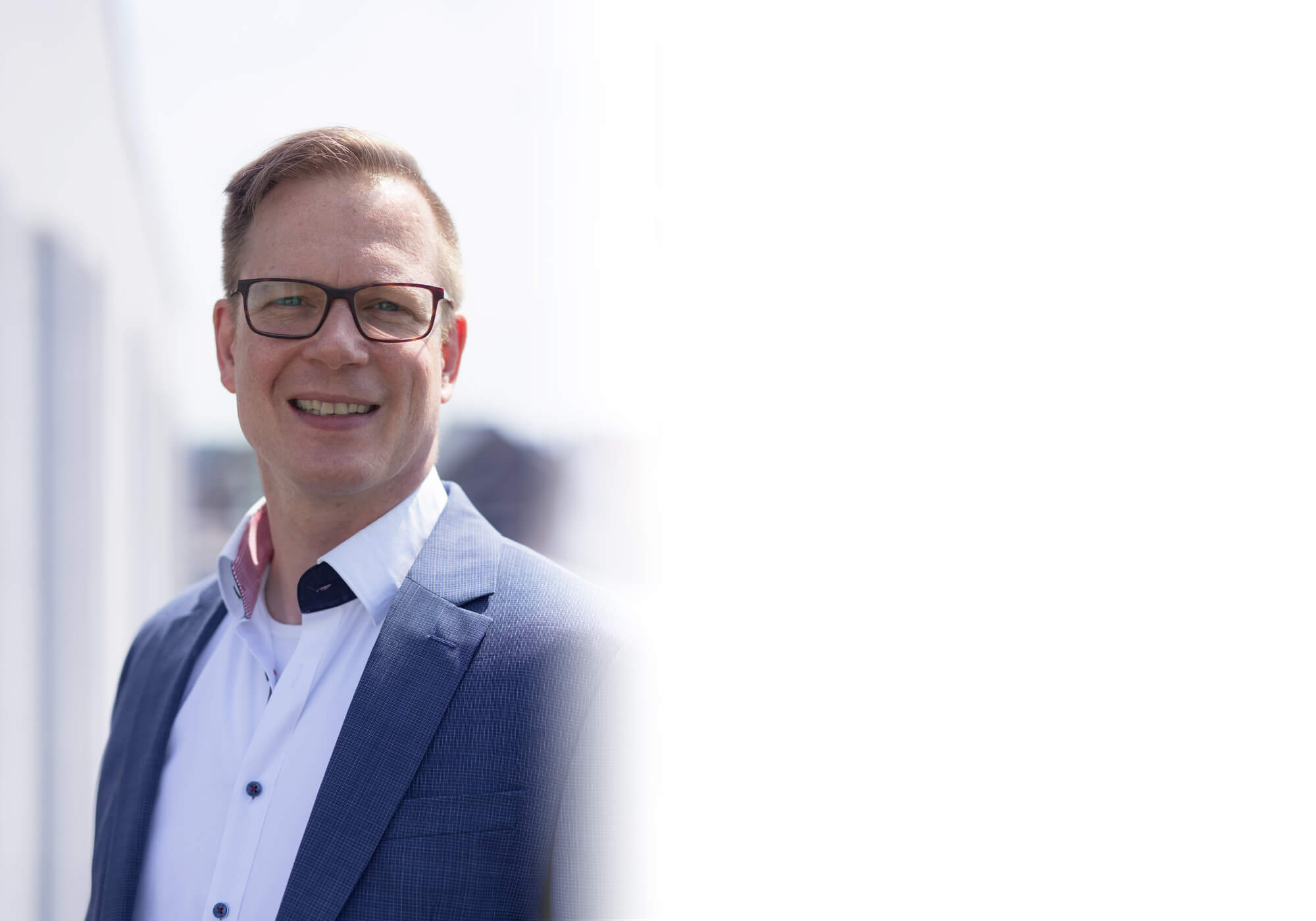 Portraitfoto von Timo Wissel im Freien. Er lächelt.