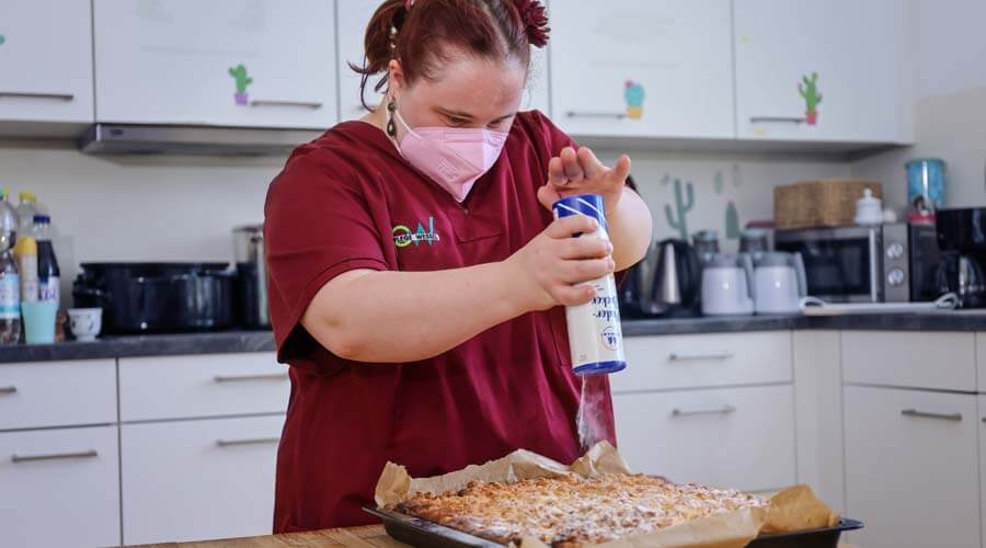 Franziska Wolf bestäubt einen Kuchen mit Puderzucker