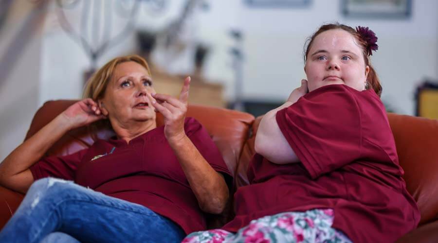 Franziska Wolf sitz mit ihrer Anleiterin auf dem Sofa und unterhält sich