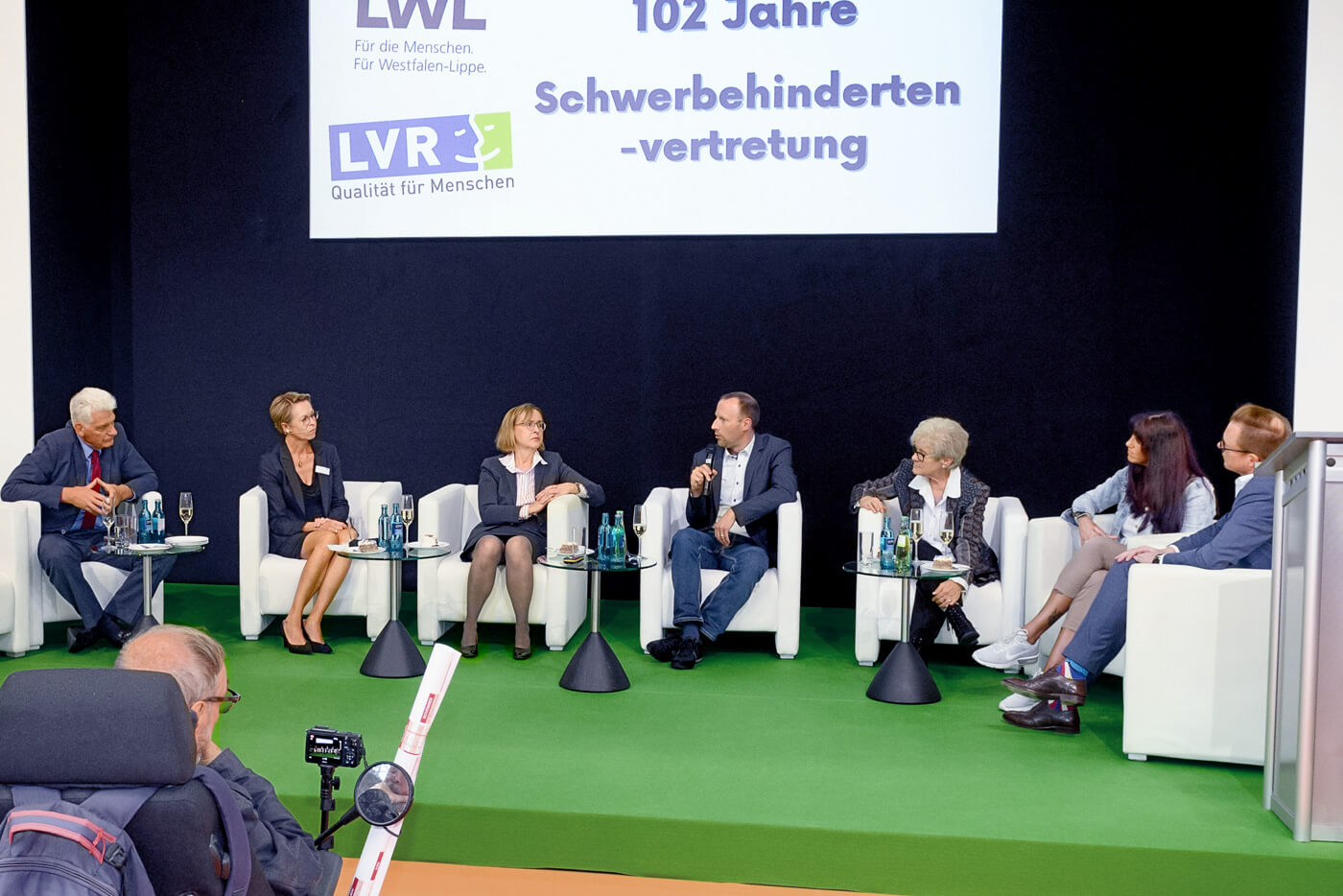 Podium des 102. Jahrestags der Schwerbehindertenvertretung mit 7 diskutierenden Personen im Viertelrund.