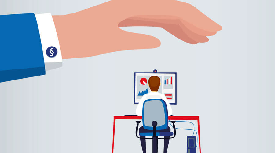Besonderer Kündigungsschutz Eine schützende Hand wird über einen Schreibtisch mit Mitarbeitergehalten (Illustration)