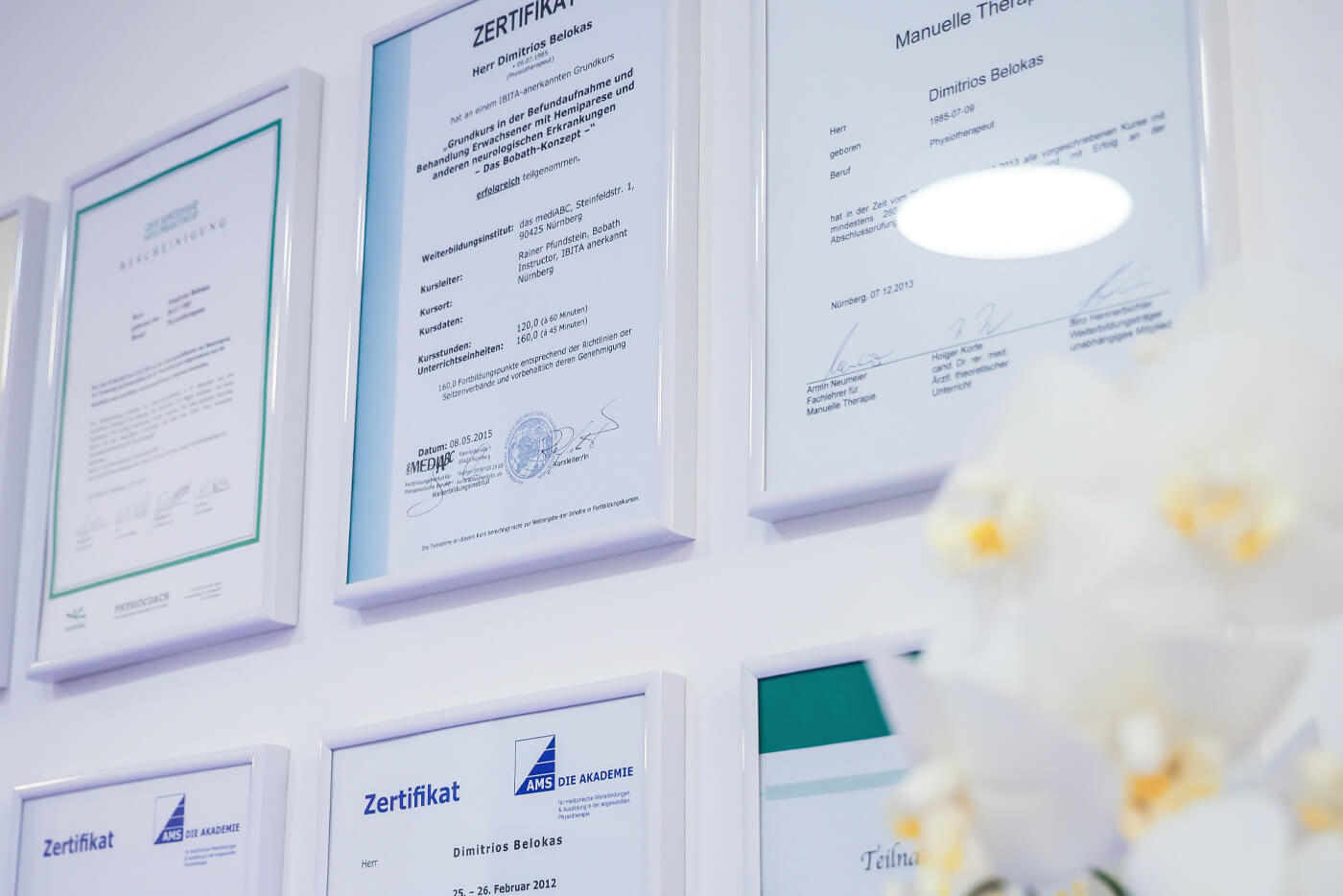 Foto von acht Zertifikaten, die bei Belokas an der Wand hängen.