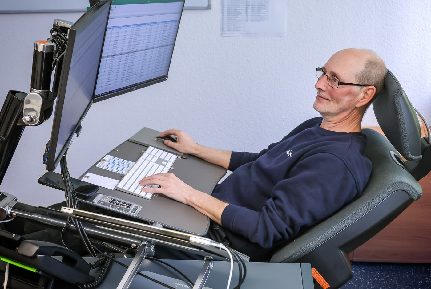 Carsten Schönebeck an seinem elektronisch verstellbaren Arbeitsplatz in halbliegender Position.