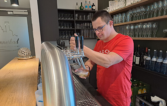 Lukas Geser zapft ein Bier an der Theke