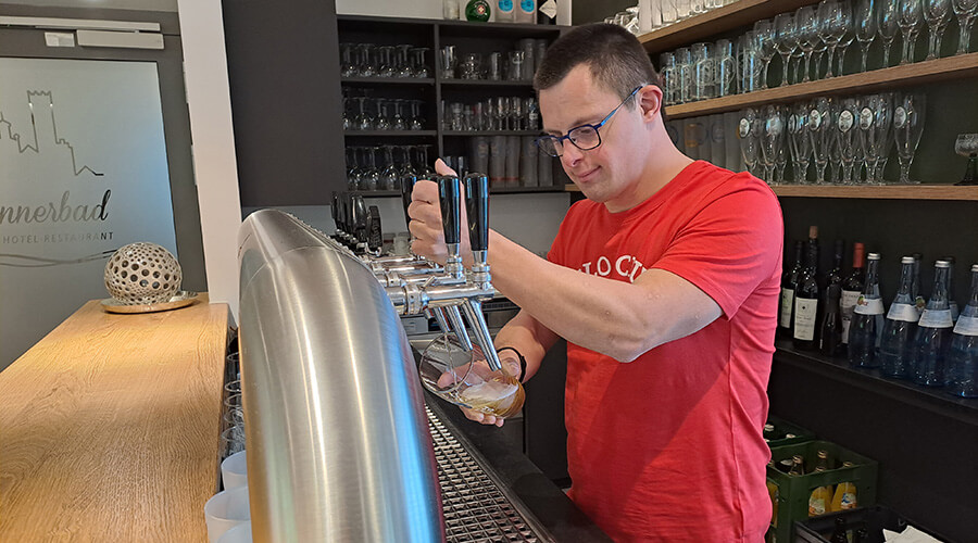 Lukas Geser zapft ein Bier an der Theke