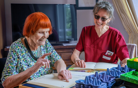 Agniezka Bartoszek unterrichtet eine Bewohnerin in Brailleschrift