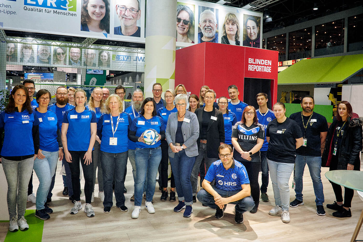 Gruppenbild des LVR/LWL-Teams am Messestand. Der Großteil trägt blaue T-Shirts mit LVR-Logo