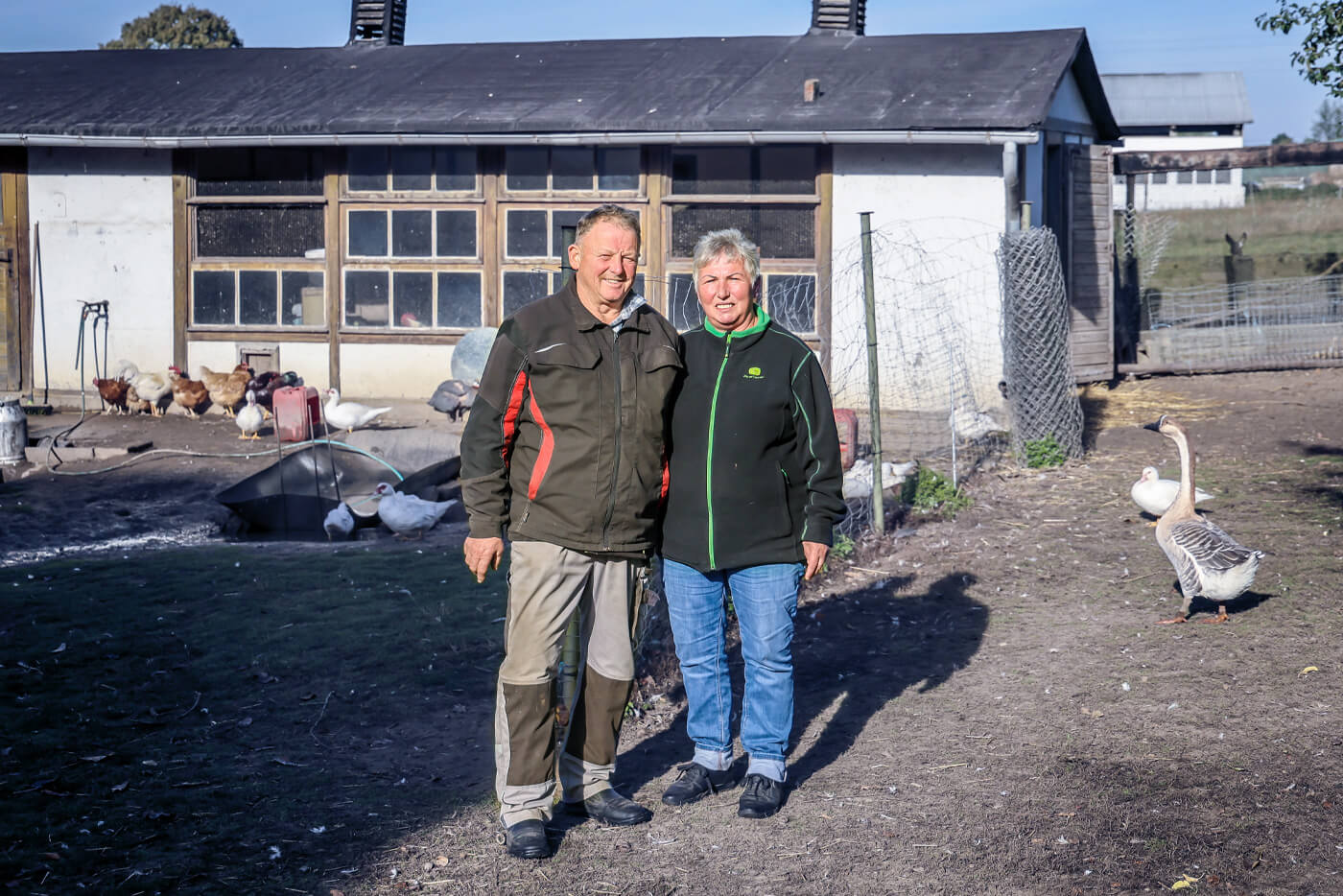 Ehepaar Leubner steht Arm in Arm vor dem Geflügelhaus. 