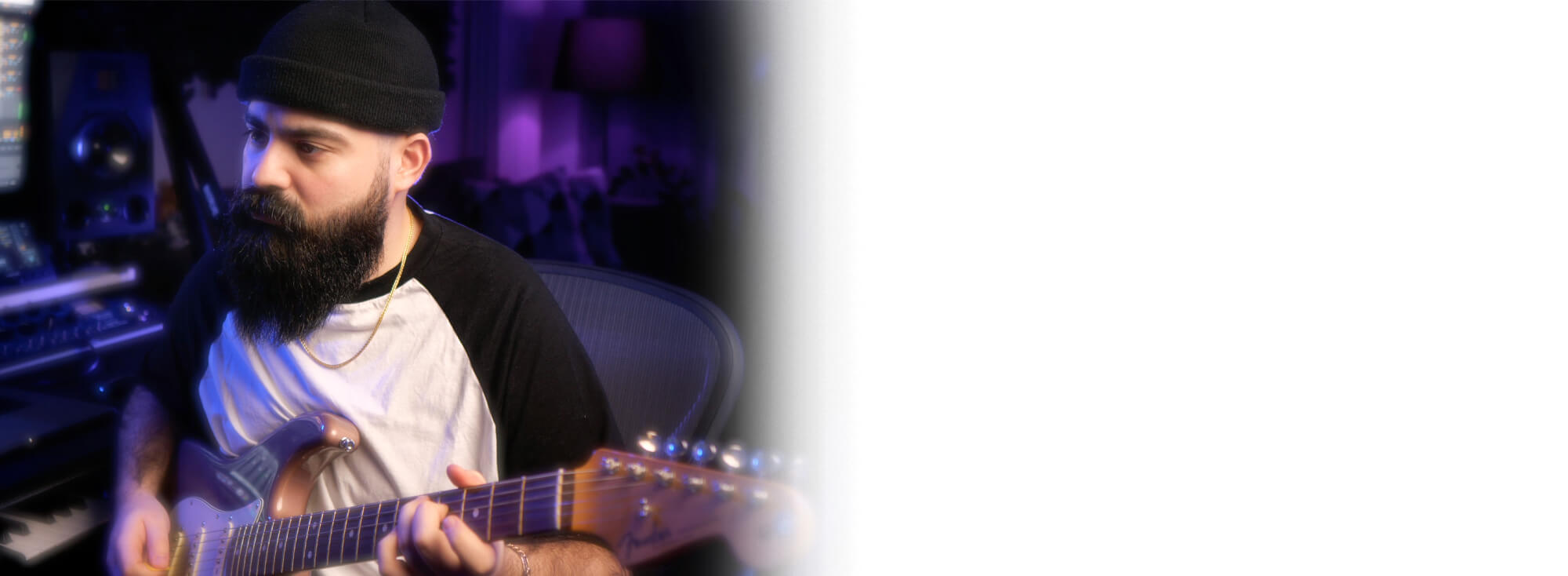 Cihan Ozaman, Künstlername Kemelion, sitzt vor seinem Equipment und spielt E-Gitarre.