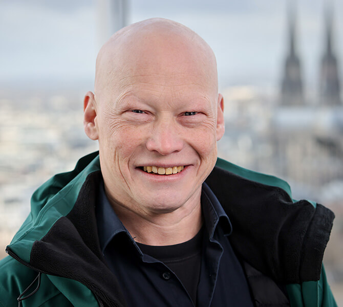 Das Foto zeigt Swen Windhaiser, im Hintergrund ist der Kölner Dom zu sehen.