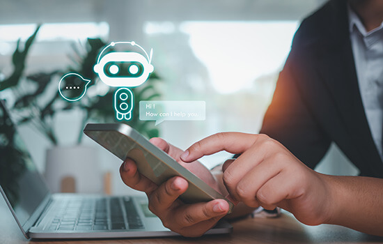 Die Fotomontage zeigt zwei Hände, die ein Smartphone halten. Darüber ist die Zeichnung eines Roboters zu sehen und eine Sprechblase: "Hi. How can I help you?"