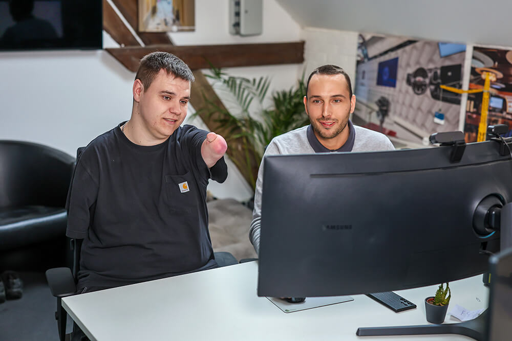 Yannick Boos und Benedikt Nöchel sitzen gemeinsam an einem PC-Monitor.