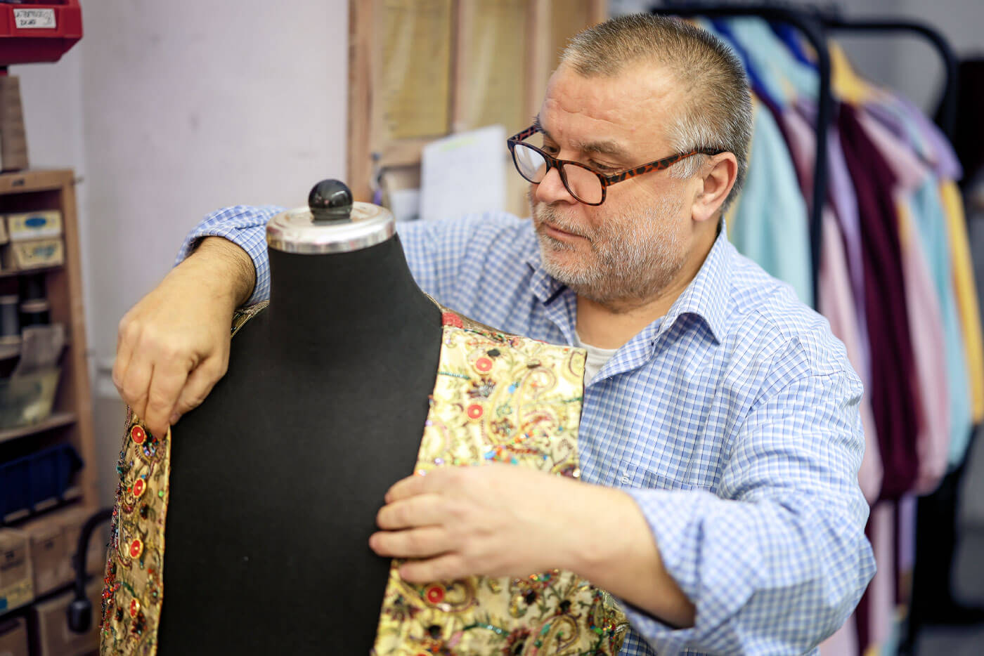 Der Herrenschneider Yusuf Aydoğan legt Stoff um eine Schneiderpuppe.