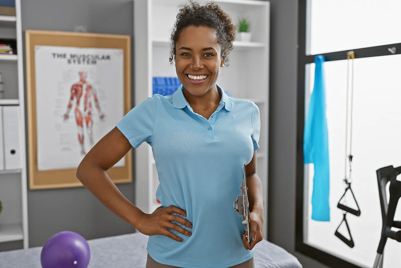 Physiotherapeutin, Foto: Krakenimages.com/Shutterstock Eine Frau steht in einem Raum einer Physiotherapie-Einrichtung.