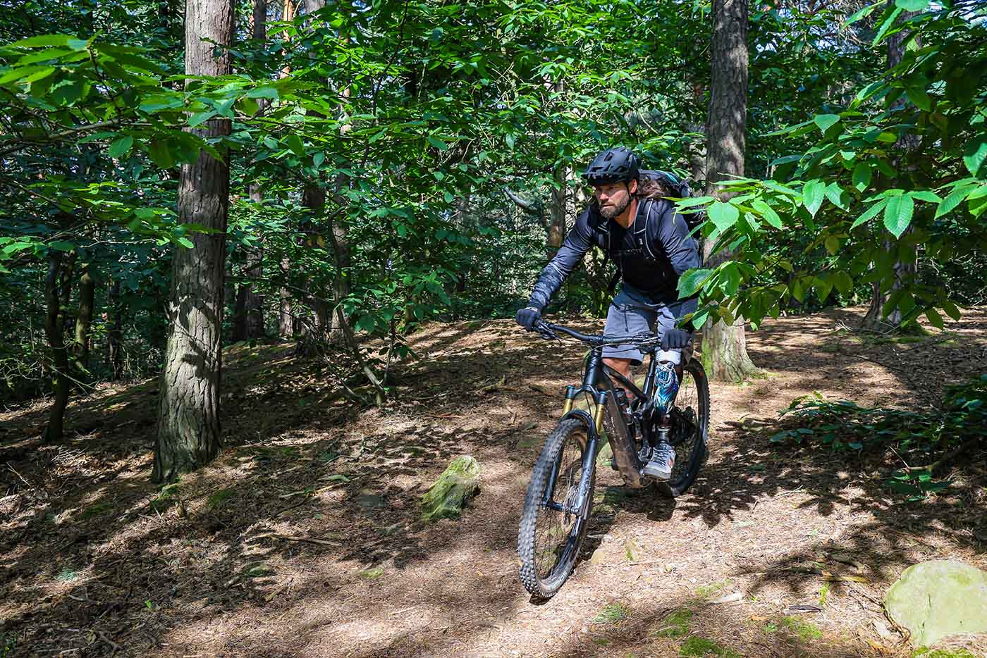 Alexander Butz fährt auf einen Mountainbike durch den Wald.