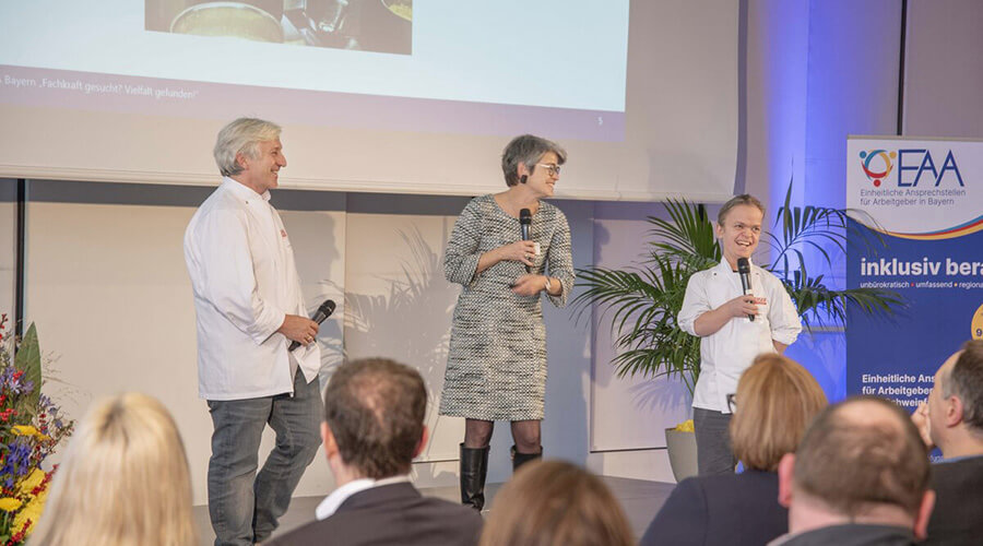 Friedrich Bönisch und Bernhard Reiser stehen gemeinsam auf einer Bühne bei einer Veranstaltung der EAA in Bayern.