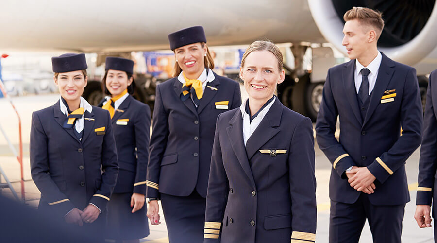 Lufthansa Gruppenbild l © Timo Ackermann Gruppenbild einer Flugzeugbesatzung am Flughafen vor einem Flugzeug.
