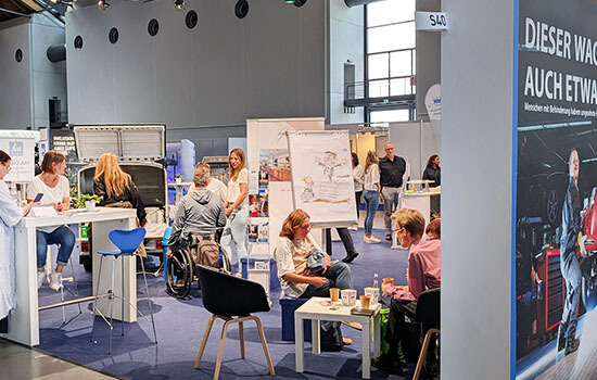 Ein Messestand gefüllt mit Besuchern. 