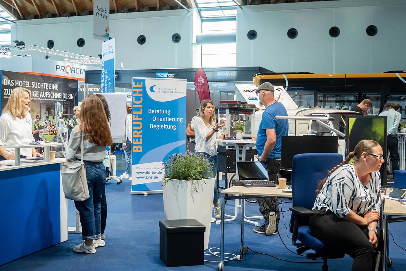Ein Messestand auf dem sich Menschen miteinander unterhalten. 