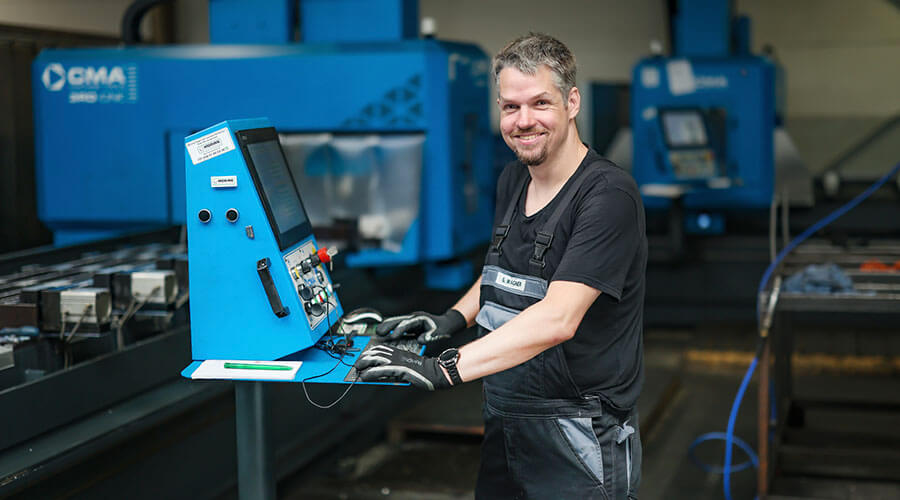 Arbeiter am Bedienterminal | © Rupert Oberhäuser Ein Arbeiter der an einem Bedienterminal steht.