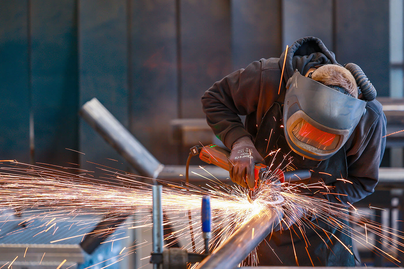 Ein Arbeiter bearbeitet Metall mit einem Schweißgerät.