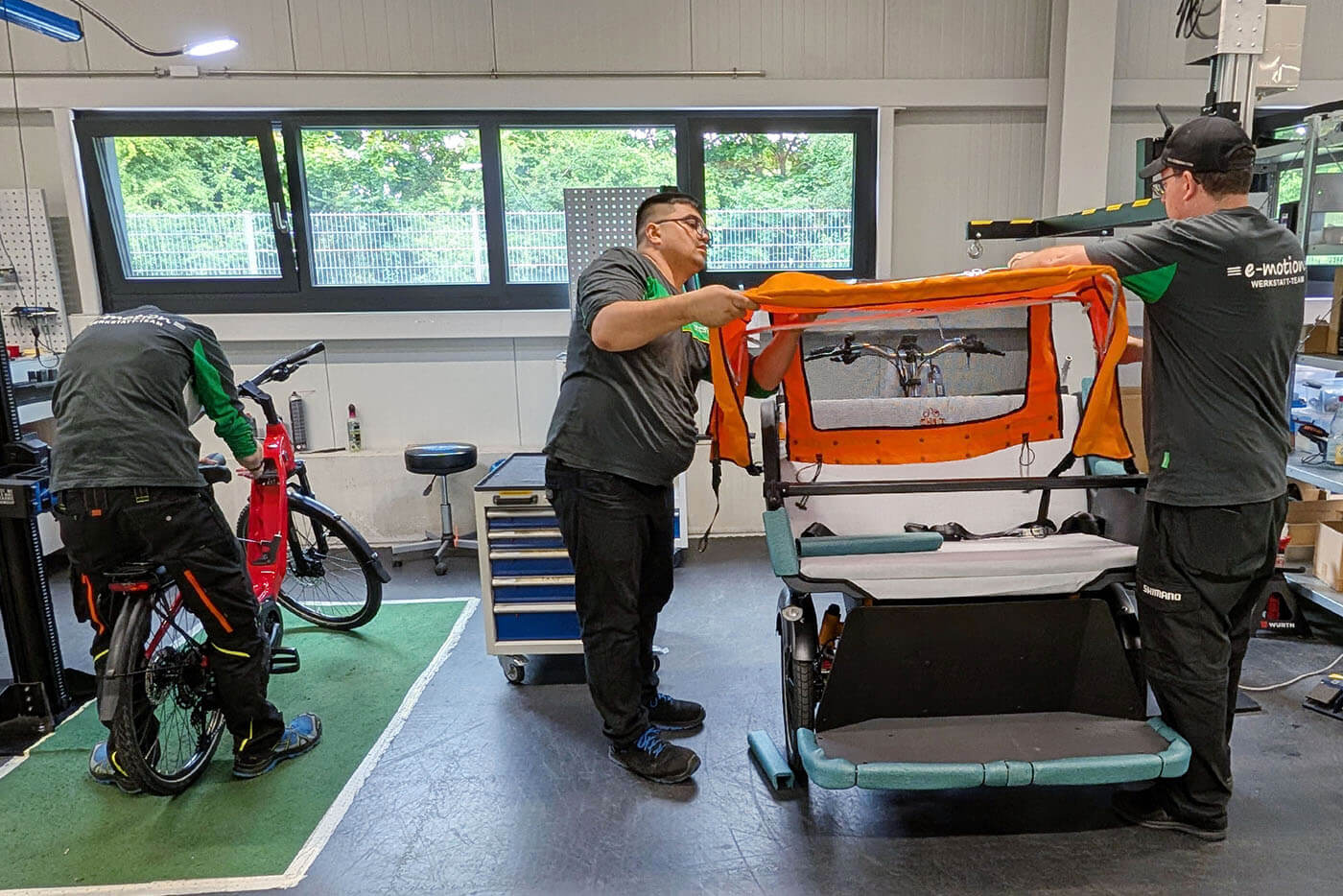 2 Mitarbeiter bauen eine Rikscha zusammen