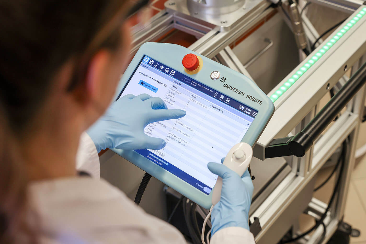 Eine Laborantin bedient das Terminal des Cobot