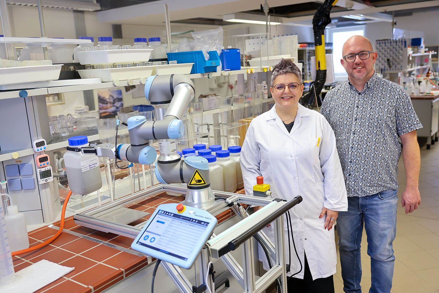 Jörg Simon und Annett Jost stehen neben dem Cobot
