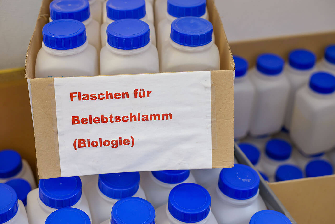 Plastikflaschen mit Proben, darauf ein Schild: "für Belebtschlamm"
