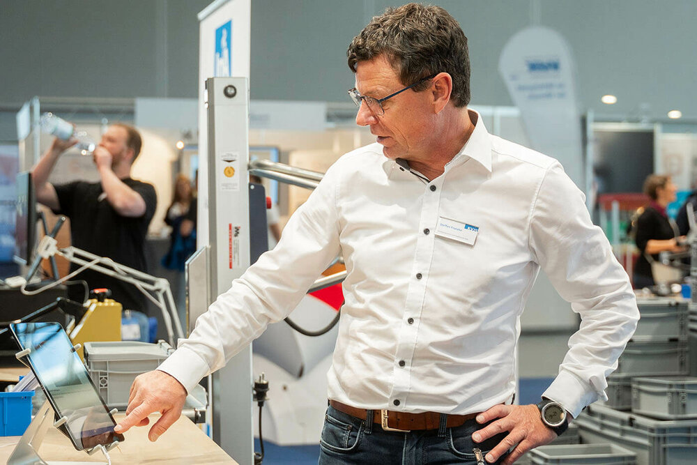 Person zeigt auf eine Coaching-App, die bei der Veranstaltung präsentiert wurde