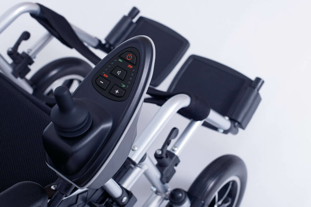 Nahaufnahme eines Steuermoduls am Griff eines Rollstuhls.