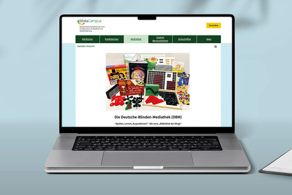 Schmuckbild Blindenmediathek l © 2024 udovichenko/Shutterstock Auf einem aufgeklappten Laptop ist die Startseite der Online-Blindenmediathek zu sehen.