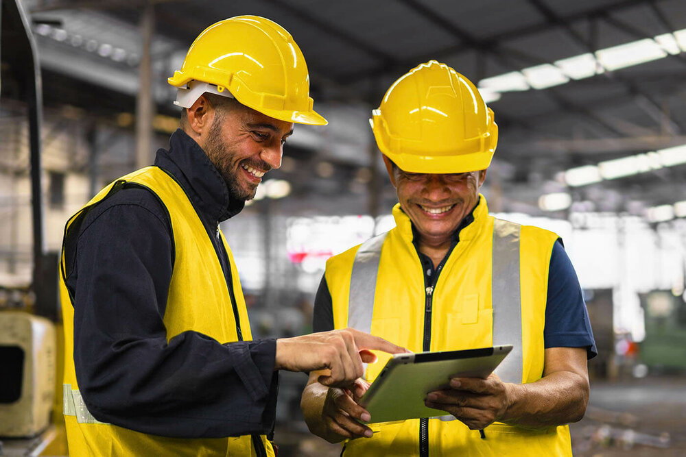 Zwei Arbeiter in Signalkleidung die miteinander reden 